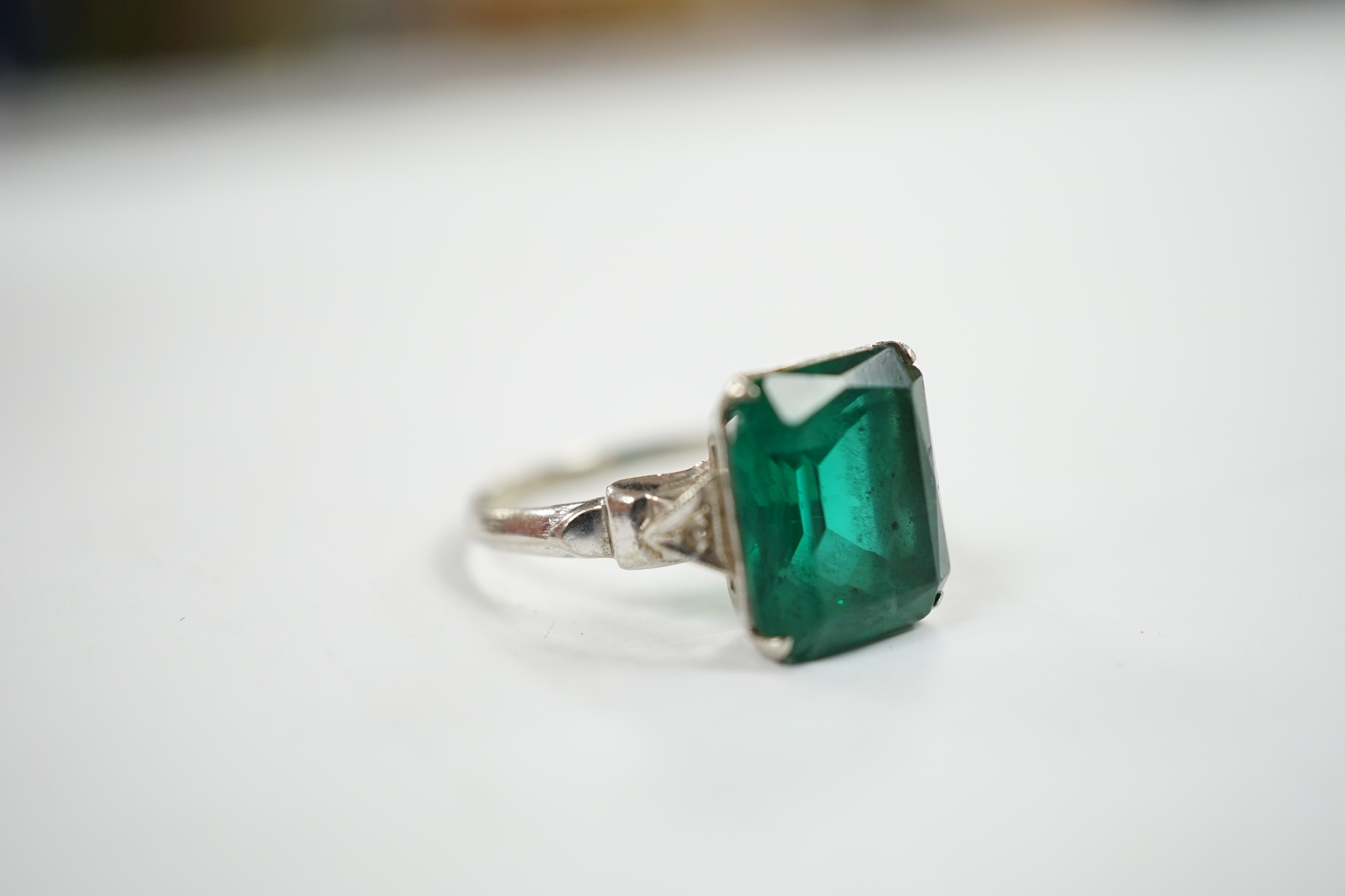 A 14k and single stone green paste set ring, with diamond chip set shoulders, size P, gross weight 3.5 grams.